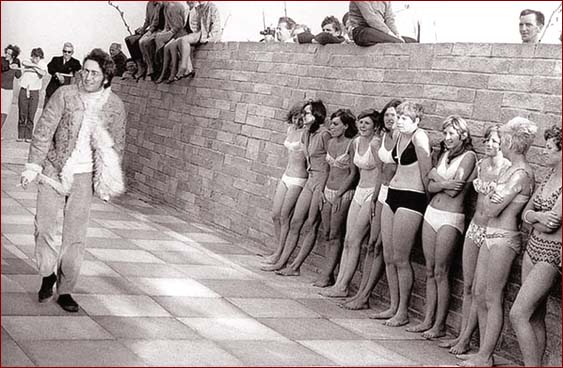 John Lennon passes by extras for the film Magical Mystery Tour.